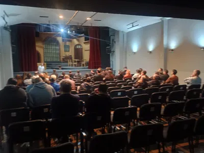 Personal asistiendo a una capacitación en una sala con escenario
