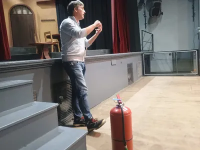 Capacitador explica junto a un extintor en una sala de capacitación