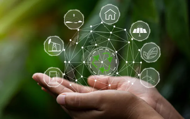 Manos sosteniendo íconos de agua, energía, naturaleza y reciclaje conectados en una red